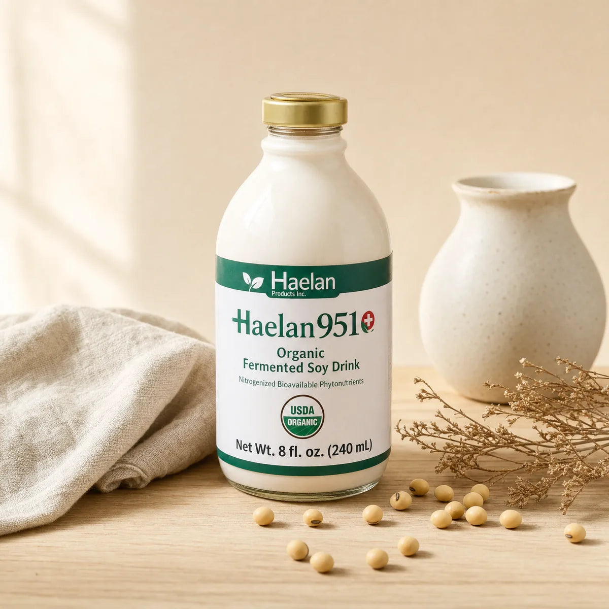 Haelan 951 organic fermented soy nutritional beverage bottle on light oak with dried botanical